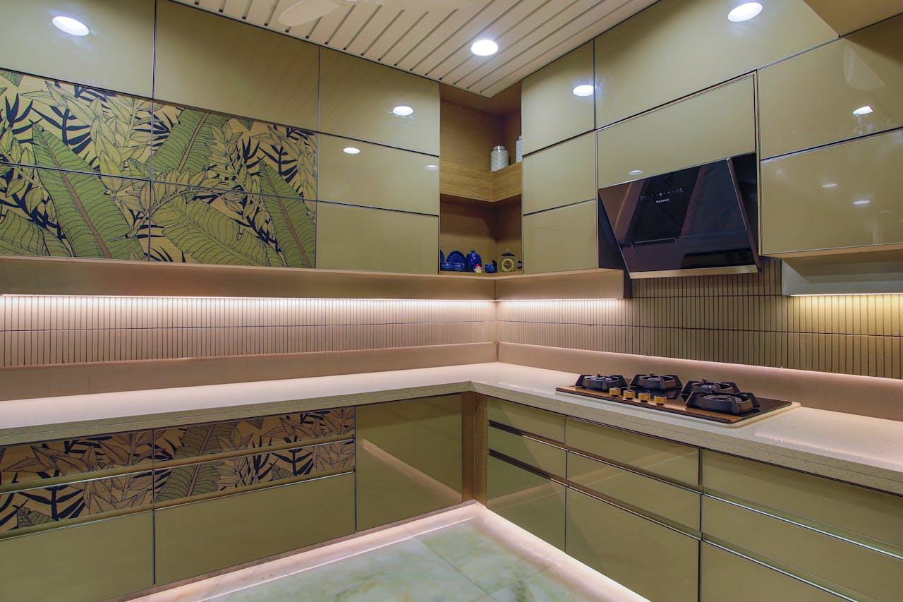 hero-img-01 Sleek kitchen design featuring green cabinets, hob, and floral accents.